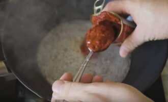 Giet de gebruikte olie uit de pan, voeg suiker, tomatenpuree en water toe. Giet de gebruikte olie uit de pan, voeg suiker, tomatenpuree en water toe.