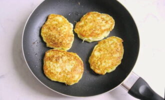 Doe een eetlepel courgettedeeg in een hete koekenpan en vorm nette pannenkoeken. Bak ze op laag vuur aan elke kant goudbruin. Dit duurt ongeveer 10 minuten.