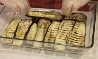 Lägg hälften av de stekta auberginema i en ugnsform, lägg på ett lager köttfärs, sedan igen – aubergine och köttfärs. Häll den resulterande såsen över allt. Lägg hälften av de stekta auberginema i en ugnsform, lägg på ett lager köttfärs, sedan igen – aubergine och köttfärs. Häll den resulterande såsen över allt.