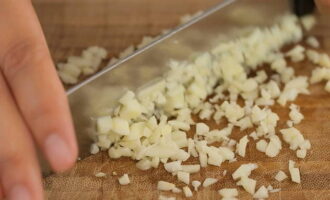 Bóc vỏ tỏi, dùng phần rộng của dao ấn vào và băm thật nhuyễn.