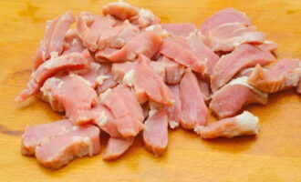 Spalam carnea de porc si o usucam cu un prosop de hartie. Tăiați carnea bucăți și sare. Ungeți tava de copt cu ulei vegetal. Asezati carnea de porc pe fundul vasului si puneti deasupra tocanita de legume. 