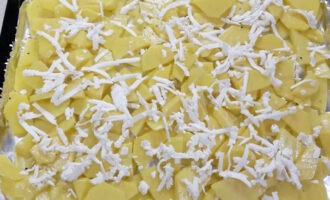 Takpan ang isang baking sheet na may foil at ilagay ang mga patatas dito. Ito ang pinakamababang layer upang sa panahon ng pagluluto ito ay puspos ng juice, na inilabas ng karne na nakahiga sa itaas nito.Grate ang keso sa isang magaspang na kudkuran at ikalat sa isang pantay na layer sa ibabaw ng mga patatas.