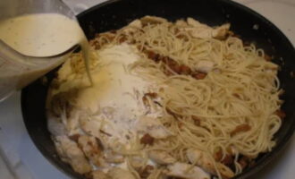 Poseu els espaguetis preparats a la paella. Ompliu-los de salsa. S'ha de reduir el foc perquè els espaguetis no es cremin. S'han de barrejar amb una espàtula de fusta o de silicona i deixar-los coure a foc lent durant 5 minuts. Com a resultat, la salsa hauria d'espessir una mica. 