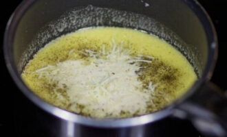 Voeg de helft van de geraspte kaas toe aan de pan.