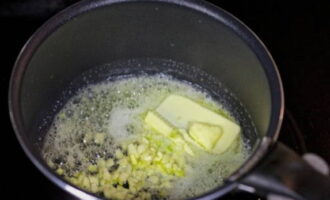 Laten we beginnen met de saus. Om dit te doen, doe je boter en fijngehakte knoflook in een pan die op laag vuur is voorverwarmd.