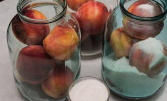 Rentar i esterilitzar pots de tres litres. Poseu els préssecs en pots i afegiu-hi sucre.