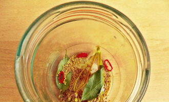 Col·loqueu els alls, els pebrots, les fulles de cirerer, la mostassa i els paraigües d'anet en pots nets i esterilitzats. Els ingredients es donen per a 1 pot de dos litres.