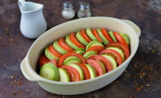 Grasa ang isang baking dish na may langis ng gulay at ilagay ang zucchini at mga kamatis dito, alternating. Magdagdag ng asin at paminta sa panlasa.