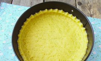 Pagkatapos ay igulong ang kuwarta. Grasa ang amag na may langis ng gulay, ilagay ang kuwarta sa loob nito at gumawa ng maliliit na bota. Tusukin ang kuwarta gamit ang isang tinidor. Ilagay ang pan na may cake sa oven, na pinainit sa 200 degrees sa loob ng 18 minuto.