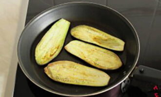 Hugasan ang mga eggplants, gupitin sa hiwa, magdagdag ng asin at mag-iwan ng 20 minuto. Pagkatapos ay iprito ang mga eggplants sa langis ng gulay sa magkabilang panig.