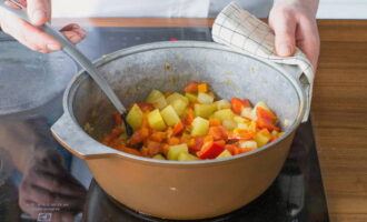Tillsätt sedan potatis och morötter och fortsätt steka i 10 minuter. Efter detta, tillsätt paprikan och tomaterna, rör om och koka i ytterligare 5 minuter.