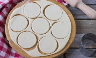 Rol het deeg vervolgens uit op een werkoppervlak en knip met een glas ronde vormstukken uit voor dumplings.
