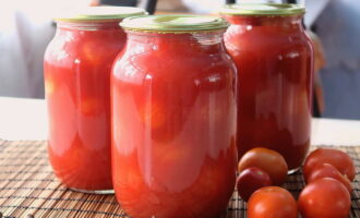 Els tomàquets apetitosos en pots de litre estan preparats. Guardeu les llaminadures en un lloc fresc.
