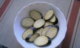 Hur lagar man läckra auberginer i georgisk stil? Vi tvättar grönsakerna och skär dem i lika tjocka skivor. Strö dem med salt, rör om och låt stå i 15 minuter.