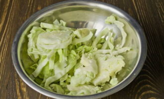 Hoe maak je een herfstsalade klaar voor de winter? Snij de witte kool in reepjes. Doe het ingrediënt in een grote kom.