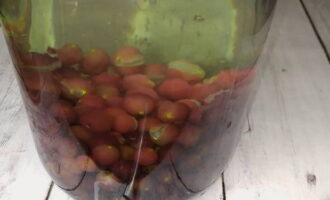 Turnați apă clocotită în borcanele cu struguri, încercând să turnați în centrul borcanului pentru a nu sparge pereții. Și lăsați fructele de pădure să se încălzească timp de 15 minute, acoperind cu capace.