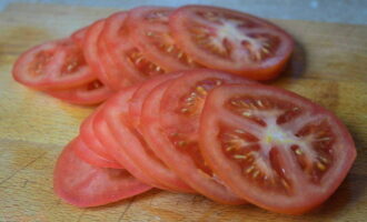 Tvätta tomaterna i rinnande vatten. Skär dem i cirklar eller skivor. Häll saften från auberginema i diskhon och fyll dem med köttfärs och örter. Lägg tomaterna ovanpå. Tvätta tomaterna i rinnande vatten. Skär dem i cirklar eller skivor. Häll saften från auberginema i diskhon och fyll dem med köttfärs och örter. Lägg tomaterna ovanpå.