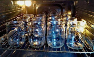 Pentru a păstra sucul de roșii pentru iarnă, avem nevoie de cutii de 8 litri. Examinăm containerul pentru defecte. Dacă nu există, curățați borcanele cu sifon și spălați-le bine. Apoi il dam la cuptor si il sterilizam. Capacele pot fi sterilizate împreună cu borcanele sau folosind apă clocotită.