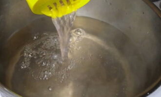 Exact după acest timp, scurgeți apa din conserve într-o cratiță, adăugați zahăr granulat, acid citric și amestecați bine. Aduceți siropul la fiert și fierbeți timp de 2-3 minute.