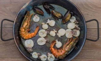 Init ang isang kawali na may langis ng oliba. Naglalagay kami ng king prawns at iba pang seafoods. Iprito ang mga ito sa loob ng 2-3 minuto. Pagkatapos ay ilagay ang mga tahong sa isang plato saglit.