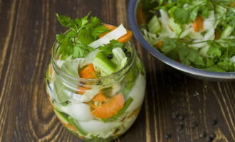 Pureer de groenten met je handen en doe ze in een glazen pot. We vullen het product aan met kruiden en vullen het met een heet mengsel van water, azijn, zout en suiker. Bedek de salade met deksels. Plaats het in een pan voor sterilisatie. Vul de potten met warm water (tot aan de hangers), breng aan de kook en steriliseer gedurende 10 minuten nadat het water kookt.