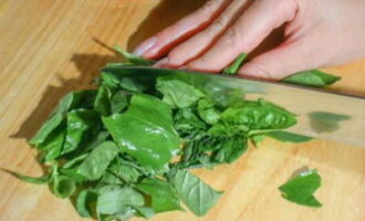 Cách làm nước sốt pesto tại nhà theo công thức cổ điển? Chúng ta cắt nhỏ lá húng quế hoặc đơn giản là xé chúng bằng tay (cách này sản phẩm sẽ ít mất đi các đặc tính có lợi hơn) và chuyển vào tô máy xay.