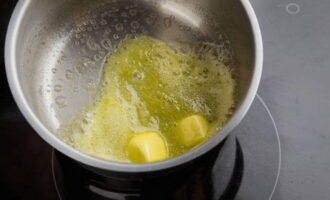 Meng in een pan de boter, die eerst zacht moet worden, voeg er olijfolie aan toe en kook de ui en knoflook in het resulterende mengsel tot ze transparant worden. 