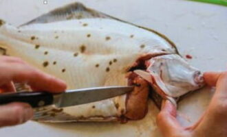 Hur bakar man läckert flundra i ugnen? Vi tvättar och torkar fisken. Skär försiktigt av huvudet och ta bort insidan.