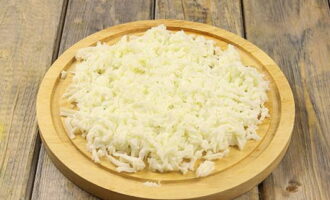 Hoe Mimosa-salade bereiden met ingeblikte vis en kaas? Kook kippeneieren en scheid het eiwit van de dooiers. Rasp eerst het eiwit.