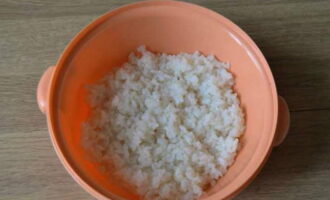 Com cuinar els pebrots farcits al forn? Anem a preparar el farcit. Bullir l'arròs en aigua amb sal durant uns 10 minuts fins que estigui mig cuit (el nucli dels grans ha de quedar ferm) i refredar.