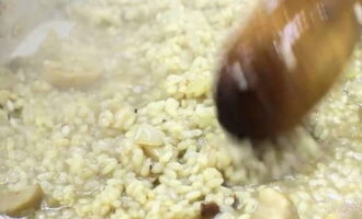 Als de wijn is verdampt, moet je de bouillon in kleine hoeveelheden erbij gieten, zodat deze net de rijst bedekt. Roer en voeg de volgende portie bouillon pas toe nadat de vorige volledig door de rijstkorrels is opgenomen.In dit stadium moet je het gerecht op smaak brengen door zout toe te voegen en het ongeveer 15 minuten op laag vuur laten staan, waarbij je regelmatig controleert of de granen niet volledig koken, maar in het midden al dente blijven. 