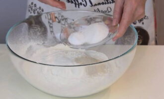 Kasunod ng lebadura, magdagdag ng butil na asukal at asin at ihalo muli gamit ang isang whisk. Pagkatapos ay gumawa ng isang butas sa nagresultang timpla sa pinakasentro.