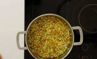Förbered under tiden resten av ingredienserna. Vi hackar potatisen och tomaterna helt slumpmässigt och hackar kålen så fint som möjligt. På så sätt blir det mer saftigt och kokar väl. Vi lägger omedelbart alla dessa komponenter i fritösen, glöm inte att lägga till konserverade bönor och fyll innehållet med vatten. Koka soppan på medelvärme.