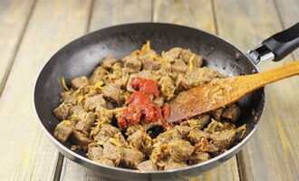Afegiu la farina, barregeu ràpidament tots els ingredients i fregiu-los durant aproximadament un minut, després afegiu-hi la pasta de tomàquet.