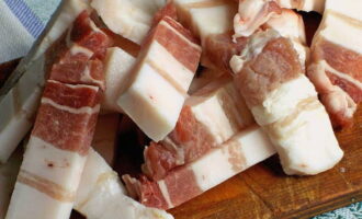 Pagkatapos ng 8 oras, gupitin ang mantika sa mga hiwa. Ngayon ay maaari mong simulan ang pagbuo ng mga kebab. Ilagay ang mga sangkap sa mga skewer sa sumusunod na pagkakasunud-sunod: singsing ng sibuyas, piraso ng karne, hiwa ng mantika.
