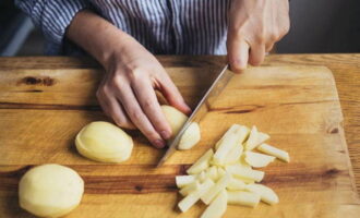 Nu är det potatisens tur. Använd en vass kniv, skär av skalet från alla knölar och tvätta dem, hacka potatisen i barer. Häll ingrediensen i pannan med buljongen.Därefter lägger vi till stekt lök och morötter.