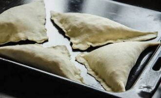 În timp ce terminăm finisajul, pornim cuptorul să se încălzească până la 190-200 de grade. Așezați plicurile khachapuri pe o foaie de copt, acoperiți deasupra cu gălbenușul pregătit și coaceți timp de 15-20 de minute. Determinăm gradul de pregătire al khachapuri după aspect și aromă.