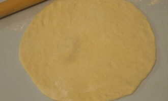 Amb un corró, convertir una bola de massa suau, de 250 grams de pes, en un pastís rodó.