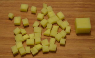 Talleu les patates a daus grans de la mida de les mongetes. Afegir al brou de carn.