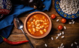 Afegiu el rostit i les mongetes a la sopa, barregeu-ho bé. Afegiu-hi el llorer, una mica d'all i salpebreu al gust, sense oblidar la sal i el pebre mòlt. Coure uns 5 minuts més i després serviu calent, adornat amb herbes picades. Bona gana!