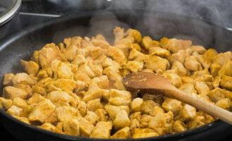 Fregir en una paella fonda, afegint oli d'oliva perquè els trossos de pollastre adquireixin una agradable tonalitat daurada. 