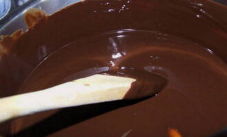 Klop de eieren met suiker, voeg voorzichtig toe aan het gesmolten chocolademengsel en roer met een garde. Voeg een paar druppels smaakstof toe en meng tot een dikke, homogene massa. 