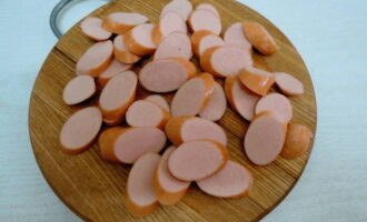 Korvarna skärs i skivor och steks lätt, sedan måste du lägga dem i en annan skål. 