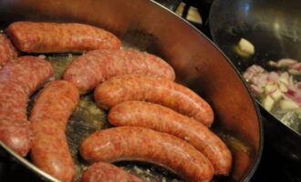 Primer bullim els embotits uns minuts en aigua bullint i després poseu-los en una paella amb oli calent.