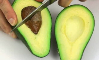 Tăiați avocado în două părți, îndepărtați pulpa și zdrobiți-l cu o furculiță până se face piure. 
