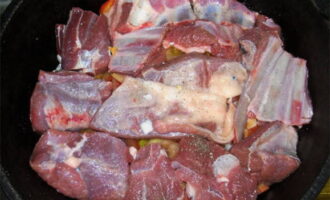 Lägg ett lager kött ovanpå grönsakerna, salta och krydda.