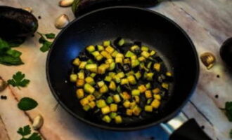 Escalfeu una paella amb oli vegetal. Poseu aquí els daus d'albergínia tallats i saleu-los al gust. Fregiu el producte fins que estigui daurat.