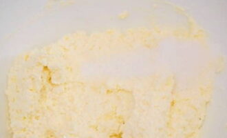 Sau đó, thêm đường cát, vanillin, nho khô vào khối sữa đông, trộn đều mọi thứ lại. 