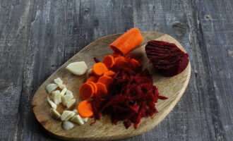 Paano magluto ng piluska (pelyuska) na repolyo na may instant beets? Hugasan at balatan ang mga gulay. Grate ang mga beets sa isang magaspang na kudkuran, gupitin ang mga karot sa manipis na hiwa, at ang bawang sa mga hiwa.