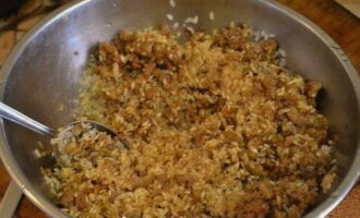 Vi tvättar riset noggrant i vatten flera gånger och lägger till det i köttfärsen, tillsätt två matskedar tomatpuré och rör om igen.